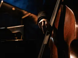 Small warm-lit jazz bar with a double bass on stage